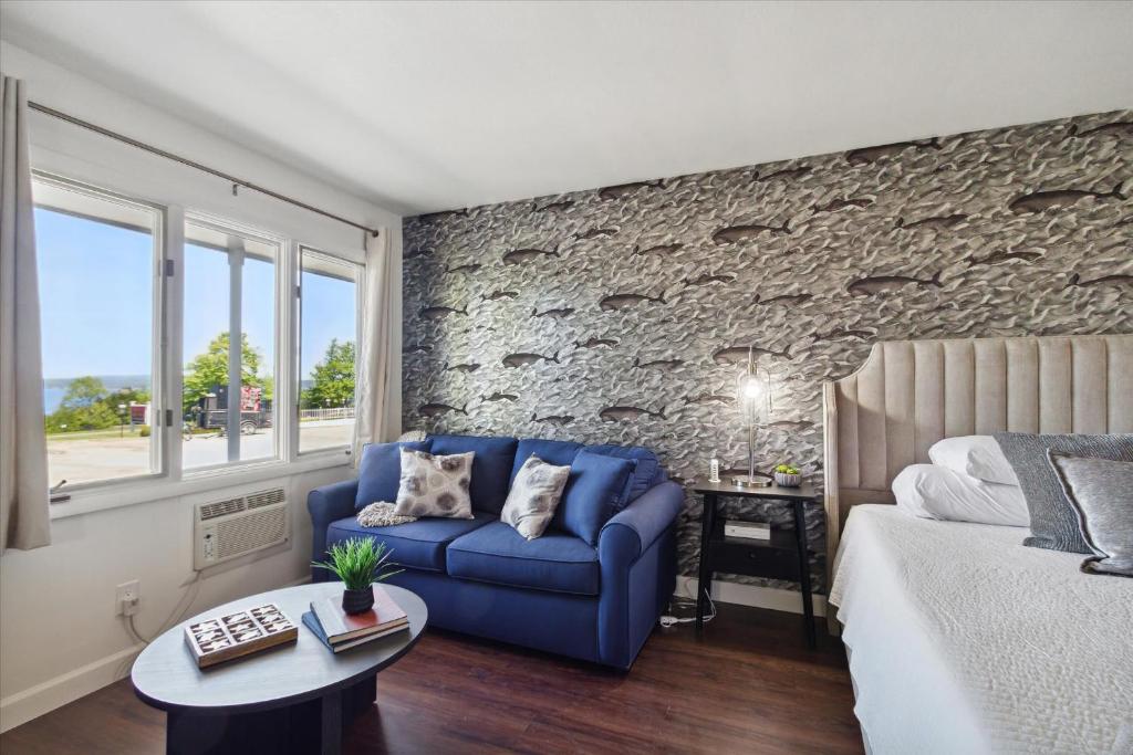 1 dormitorio con sofá azul y pared de piedra en 5mins to DT Petoskey Lakefront 50 inches 4K TV, en Petoskey