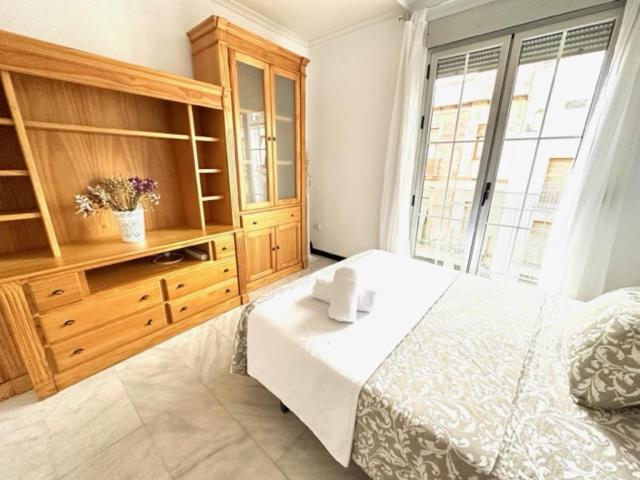 a bedroom with a large bed and a large window at Apartamento Claudio Marcelo, 1 in Córdoba