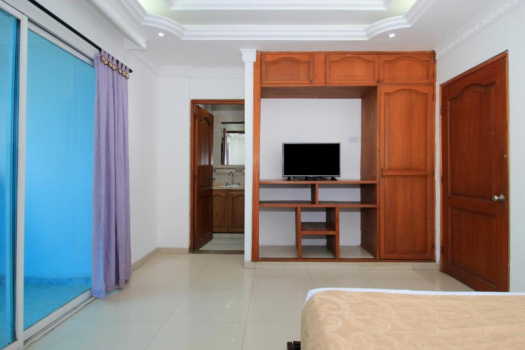Uma televisão e/ou sistema de entretenimento em Hotel Abi Inn By GEH Suites
