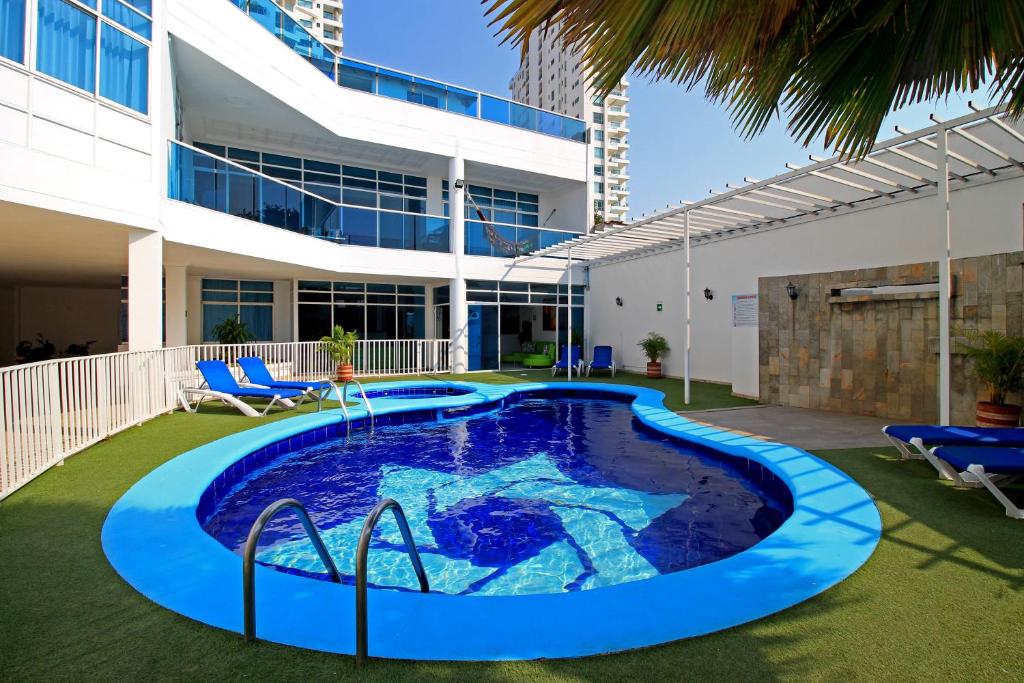 a swimming pool in the yard of a building at Hotel Abi Inn By GEH Suites in Cartagena de Indias