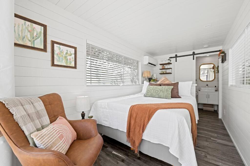 1 dormitorio blanco con 1 cama y 1 silla en New The Saguaro-Tiny Shipping Container Home en Fredericksburg