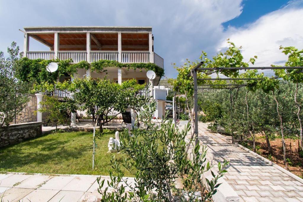 ein Garten mit einem Haus im Hintergrund in der Unterkunft Apartments Jadranka in Grebaštica