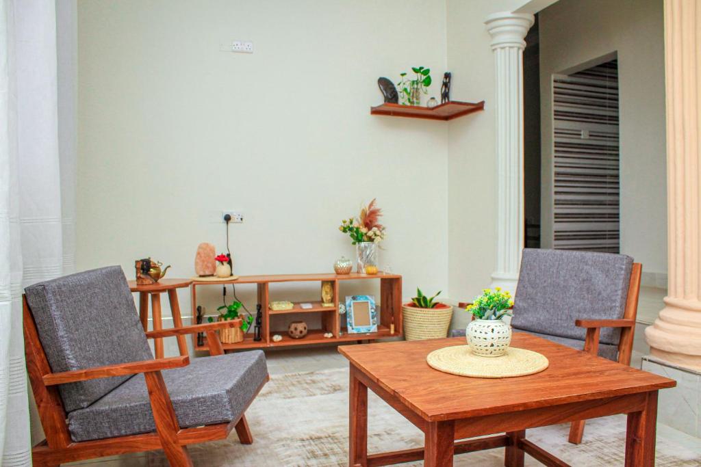 a living room with two chairs and a table at Kwale Residence in Kiembi Samaki