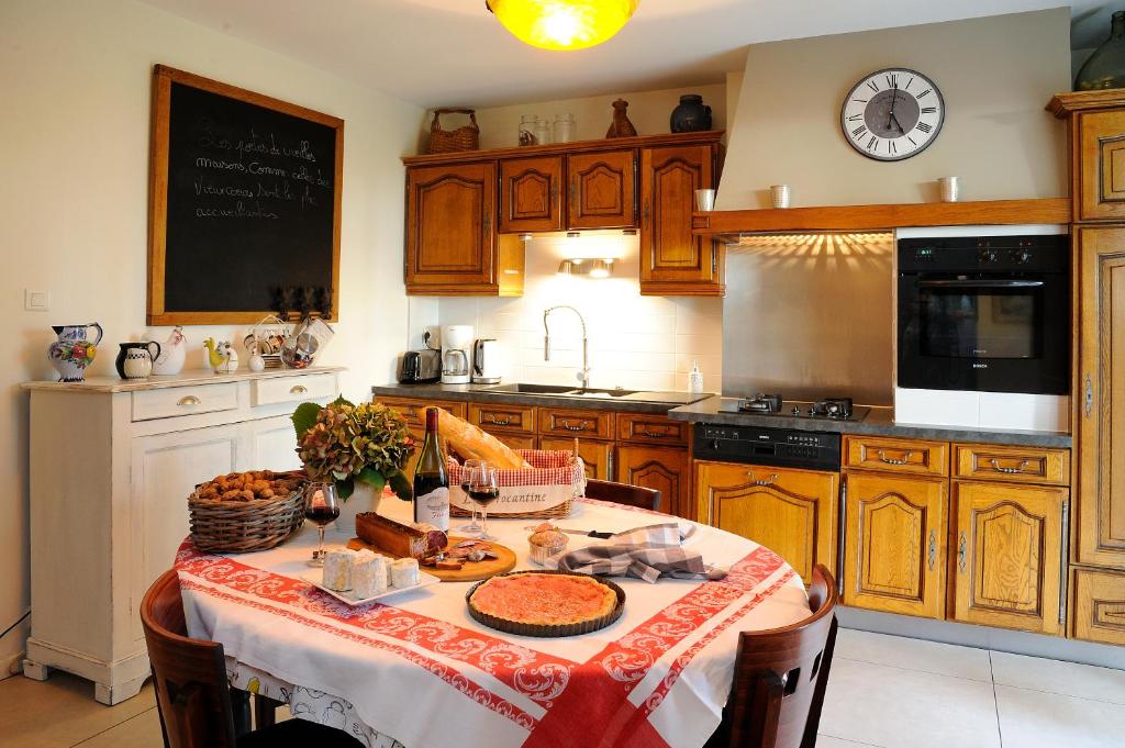 kuchnia ze stołem z jedzeniem w obiekcie La Brocantine w mieście Corcelles-en-Beaujolais