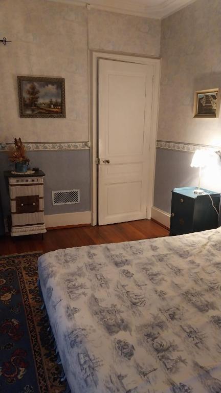 a bedroom with a large bed and a door at La chambre bleue in Bussang