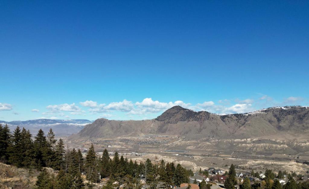 uma vista para um vale com montanhas ao fundo em New Spacious Studio Suite with Mountain Views em Kamloops
