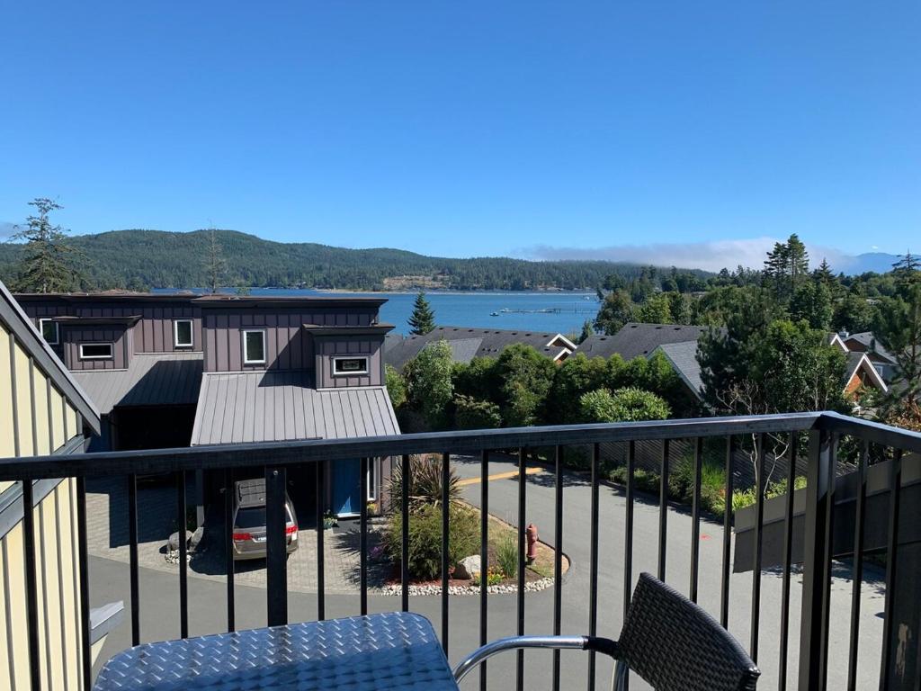a balcony with a view of a lake at Race Rocks Townhouse - Sooke in Sooke