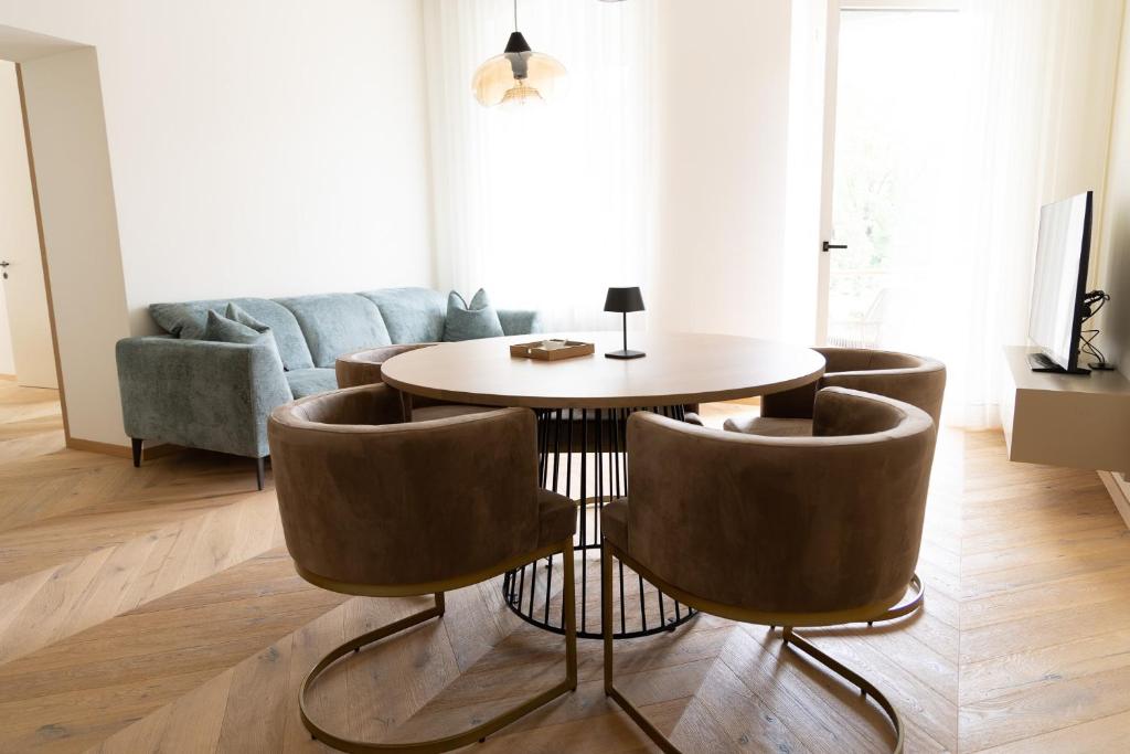una sala de estar con una mesa y sillas en Luxury Apartment Villa Ortler, en Merano