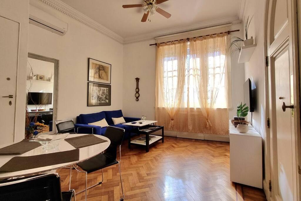 a living room with a table and a blue couch at Libertador recoleta in Buenos Aires