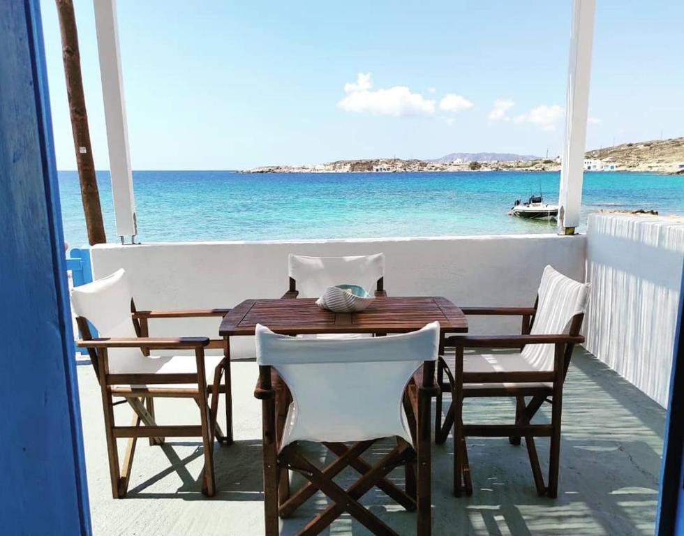 una mesa y sillas en un balcón con vistas al océano en Apleton Beach House Kimolos at Zacharias Beach en Kimolos
