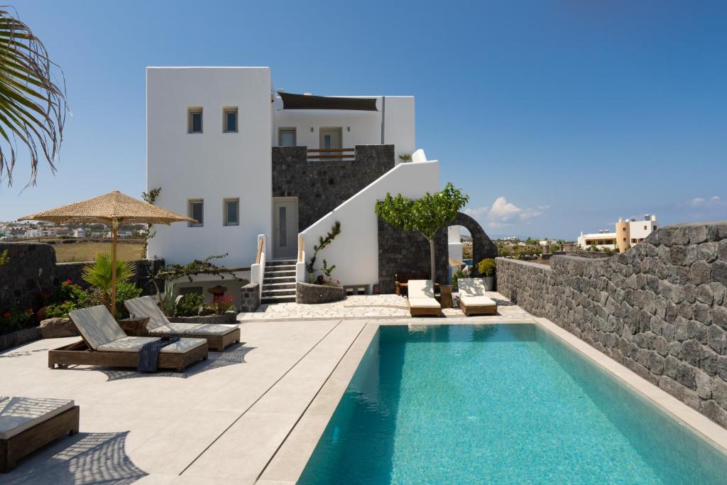 a villa with a swimming pool and a building at Santa Mar ECO Suites in Karterados