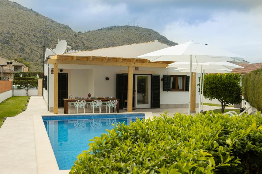 a villa with a swimming pool and a house at Alcudia Beach House in Alcudia