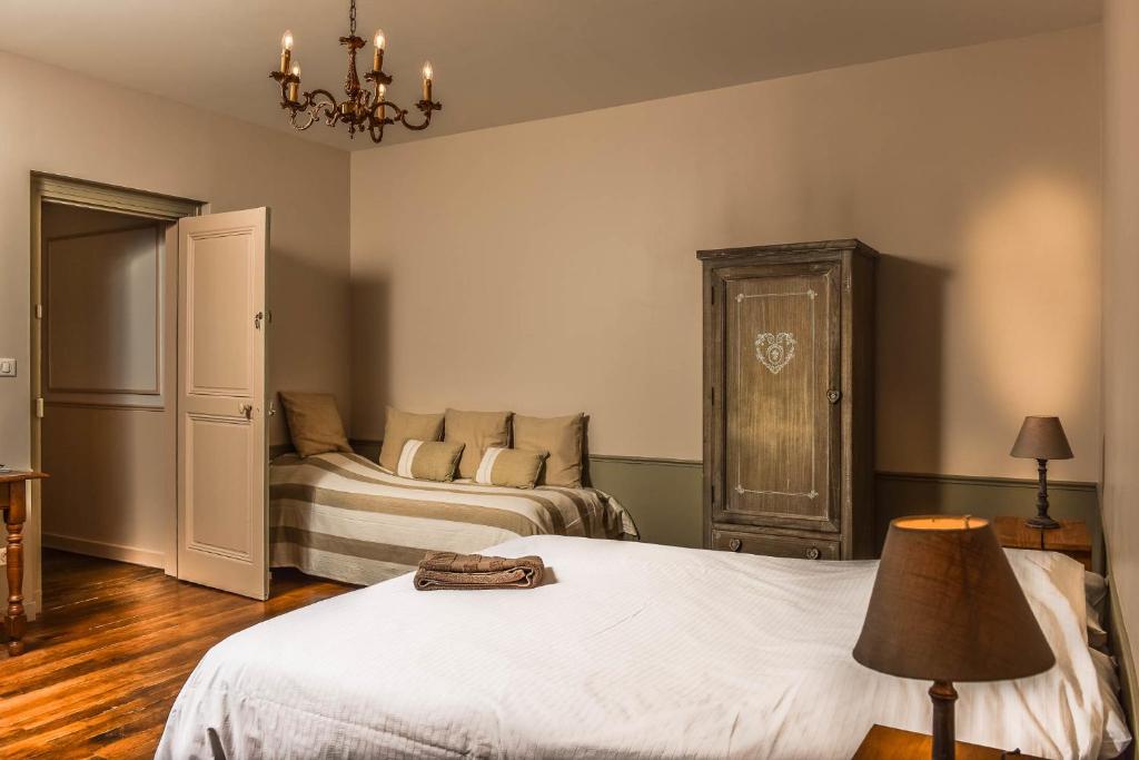 a bedroom with two beds and a chandelier at Demeure D'Argonne in Sainte-Menehould