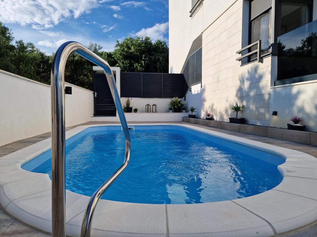 basen w domu z metalową szyną wokół niego w obiekcie Apartman Marčelina 1 with private pool w Trogirze