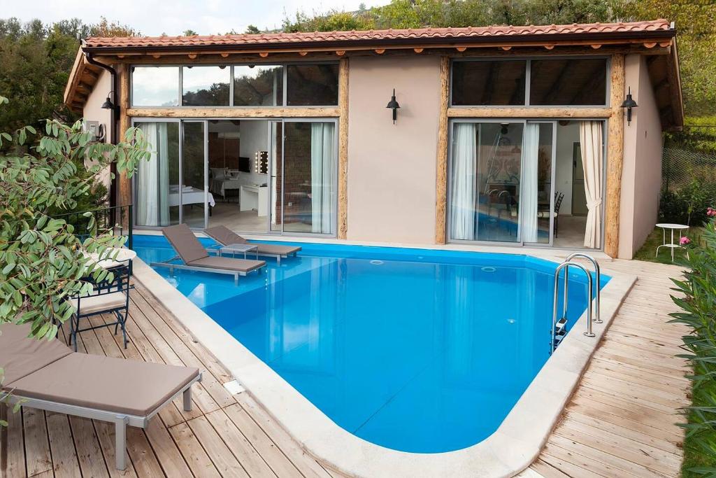 a house with a swimming pool and a patio at Villa Alaçatı (İslamlar-Kalkan) in Kaş