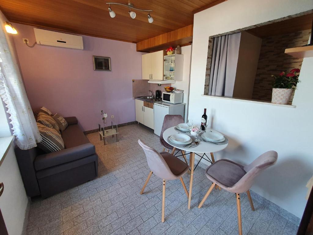 a living room with a couch and a table and chairs at Apartmani Daria & Jure in Trogir