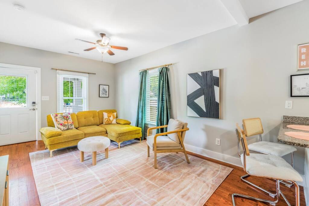 sala de estar con sofá amarillo y sillas en Bright + New - Fire Pit - Hammock - 3 bd, en Raleigh