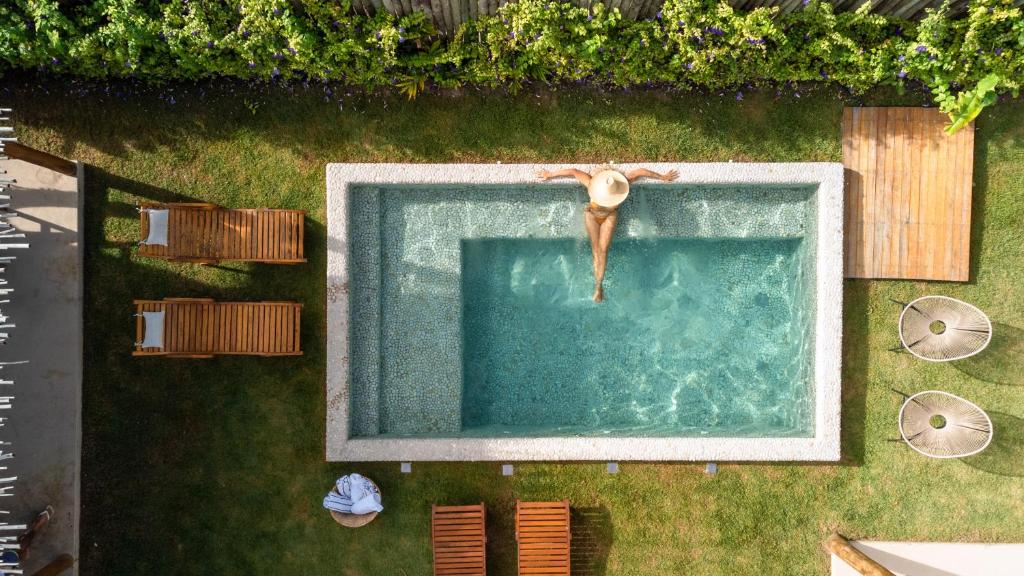 une personne plongeant dans une piscine dans l'établissement Casa das Corujas, à Praia do Espelho