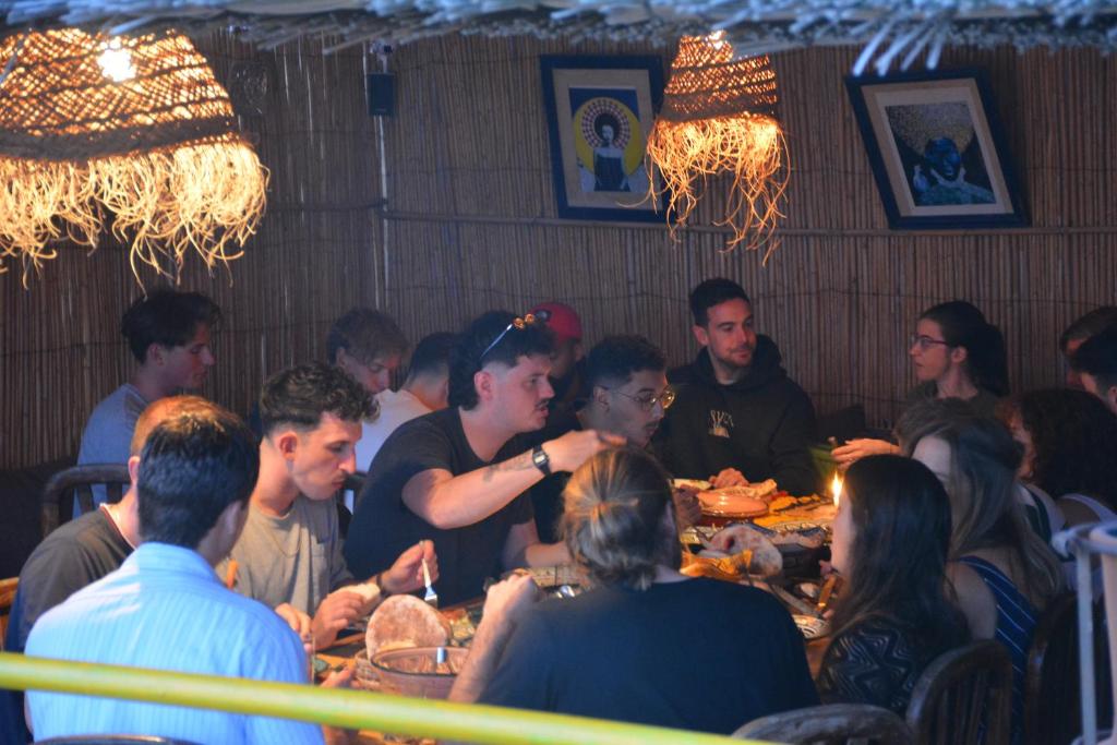 a group of people sitting at a table in a restaurant at Taghazout Roof Hostel in Taghazout