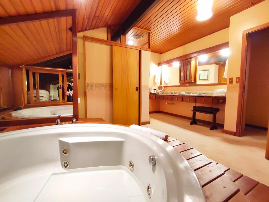 baño grande con bañera y cocina en Mais Incrível Apart no Wish Serrano en Gramado