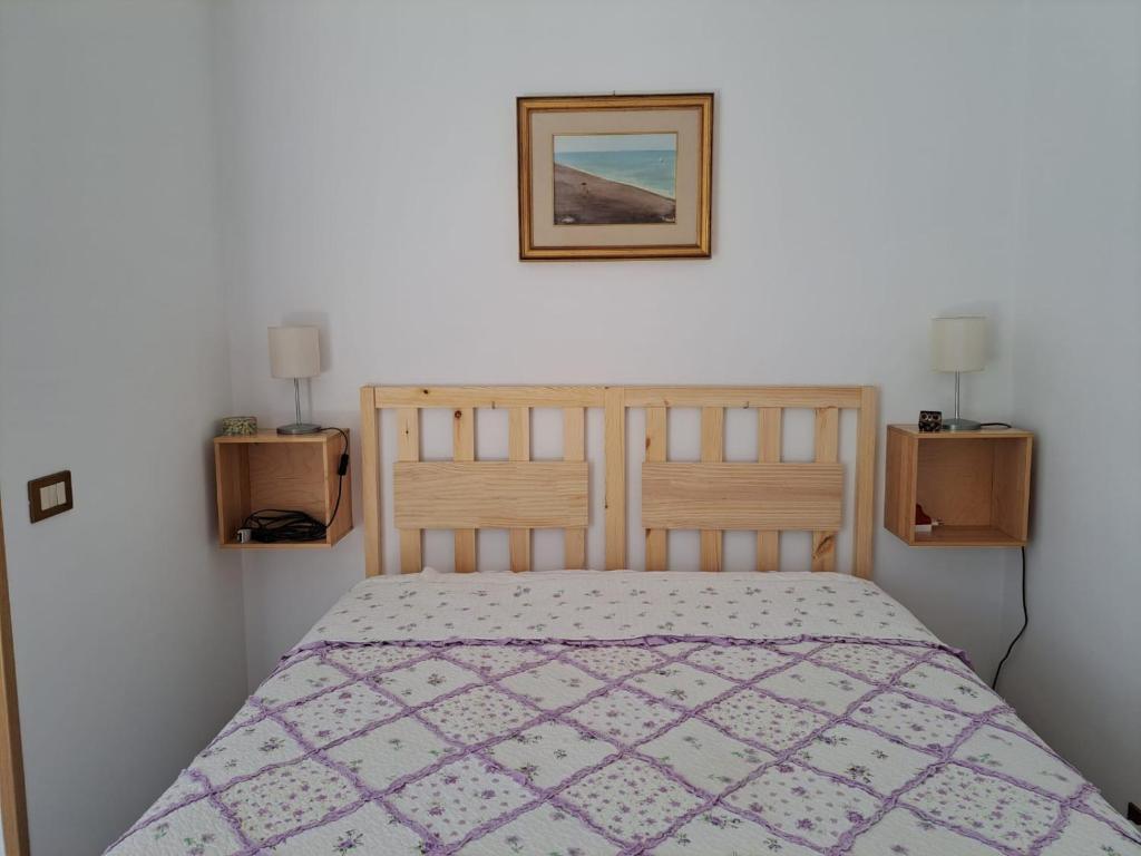 um quarto com uma cama e uma fotografia na parede em La Casetta delle sirene Anzio em Anzio