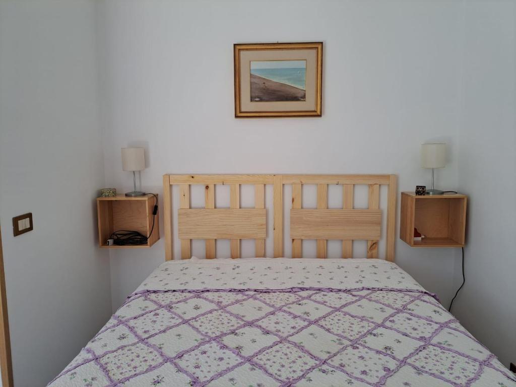 a bedroom with a bed and a picture on the wall at La Casa delle sirene sul mare di Anzio in Anzio