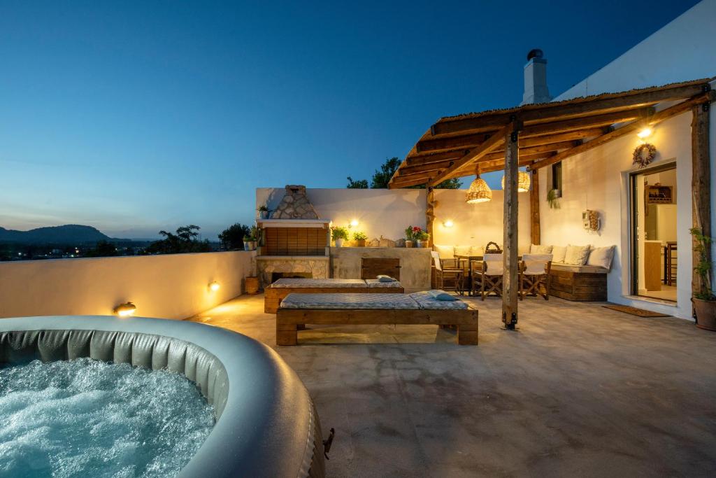 a backyard with a hot tub and a house at Mareò Traditional Retreat in Archangelos