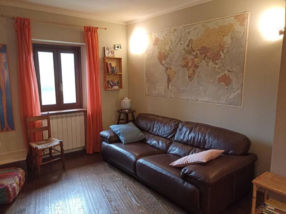un soggiorno con divano in pelle e una mappa sul muro di La Casa nel Borgo a Nocera Umbra