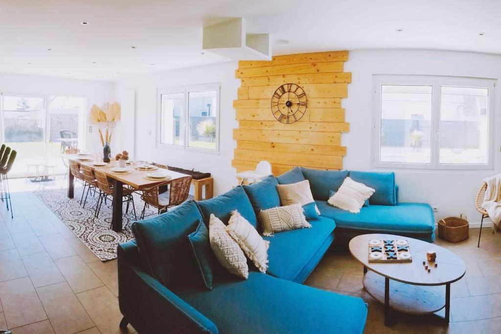 - un salon avec un canapé bleu et une table dans l'établissement Villa Mon Rêve 12 pers à 500m de la plage, à Bréhal