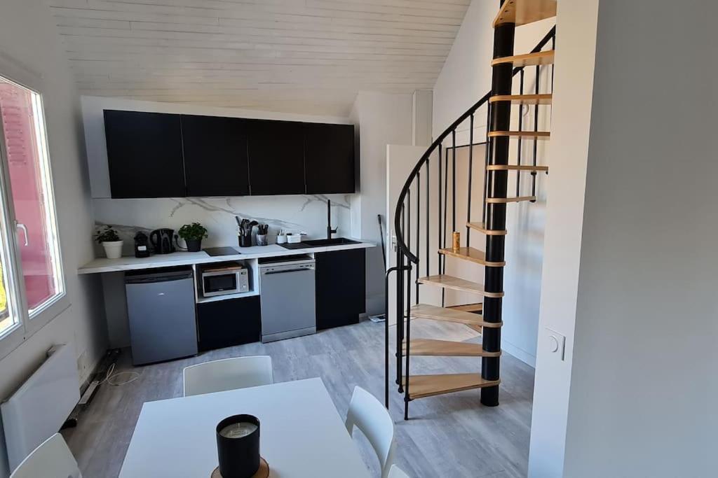 une cuisine avec un escalier et une table avec des chaises dans l'établissement Le Loft de Barbizon, à Barbizon