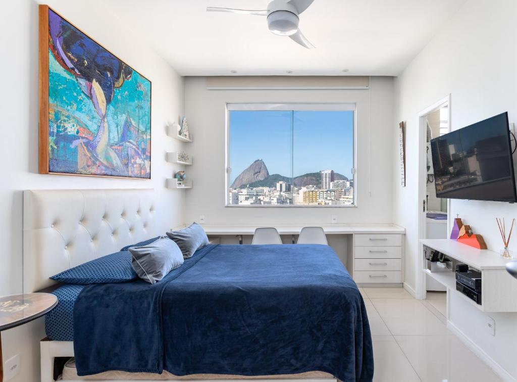 a bedroom with a blue bed and a window at Studio Catete in Rio de Janeiro