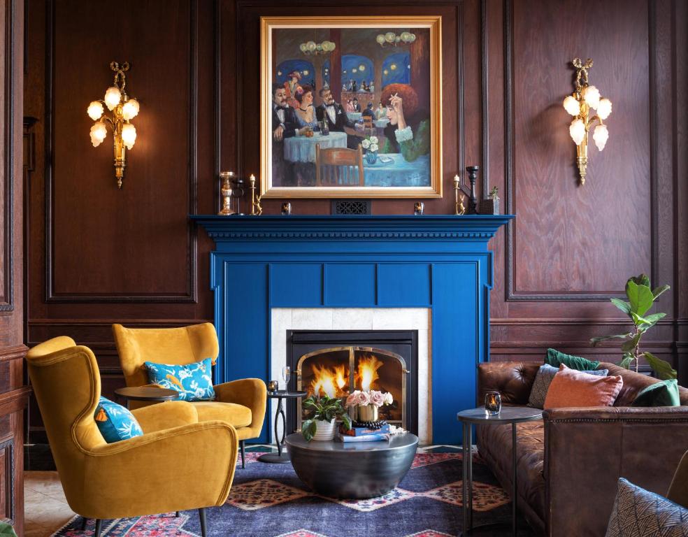 a living room with a blue fireplace with two chairs at Landmark Inn in Marquette