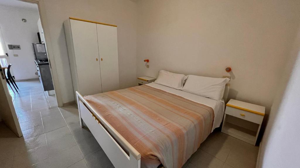 a small bedroom with a bed and a kitchen at Residence Jolly in Peschici