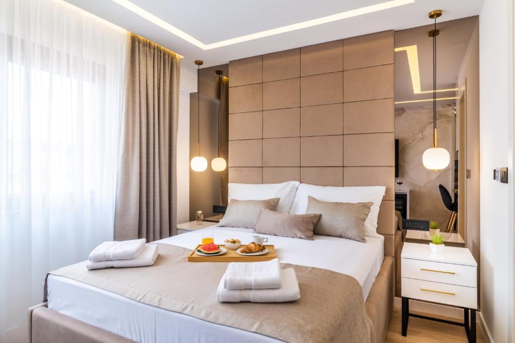 um quarto com uma cama grande e uma bandeja de comida. em Sky Residence Split em Split