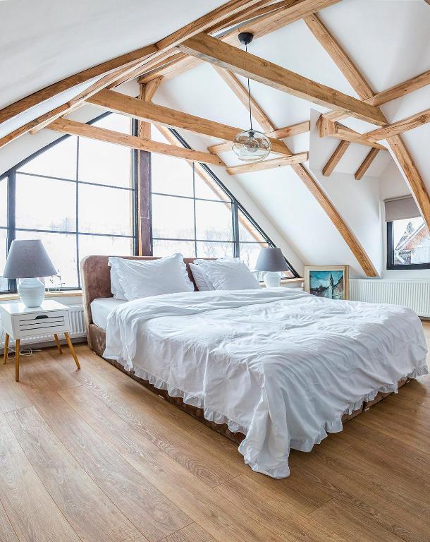 a large white bed in a room with large windows at Casa dintre dealuri in Rozavlea