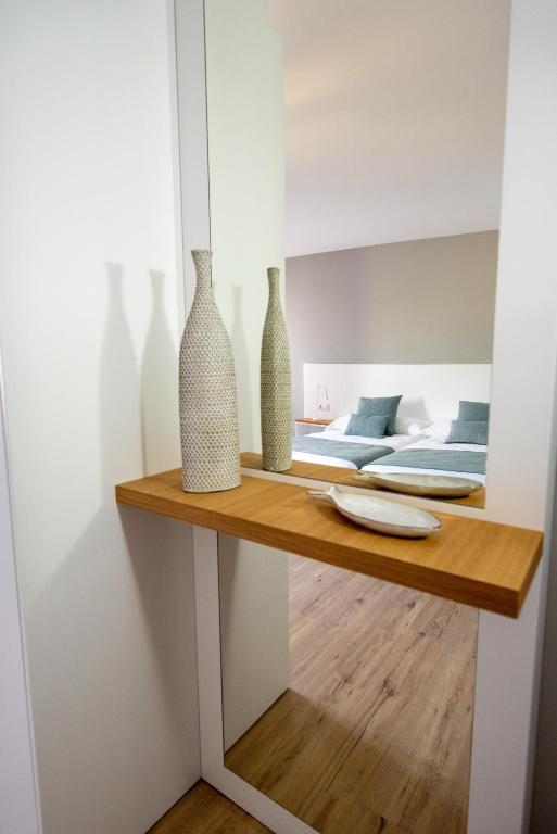 a room with two vases on a shelf with a bed at LAR DA REVOLTA in Cedeira