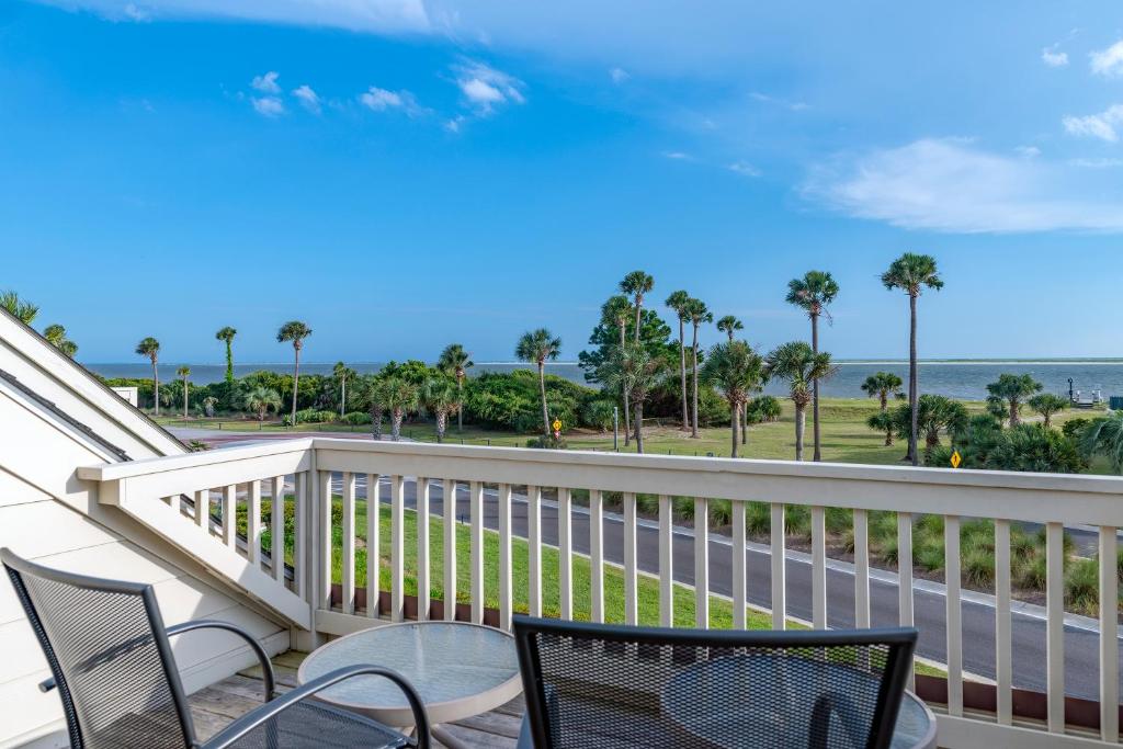 Un balcón con sillas y vistas al océano. en 703 Spinnaker Beach House, en Seabrook Island
