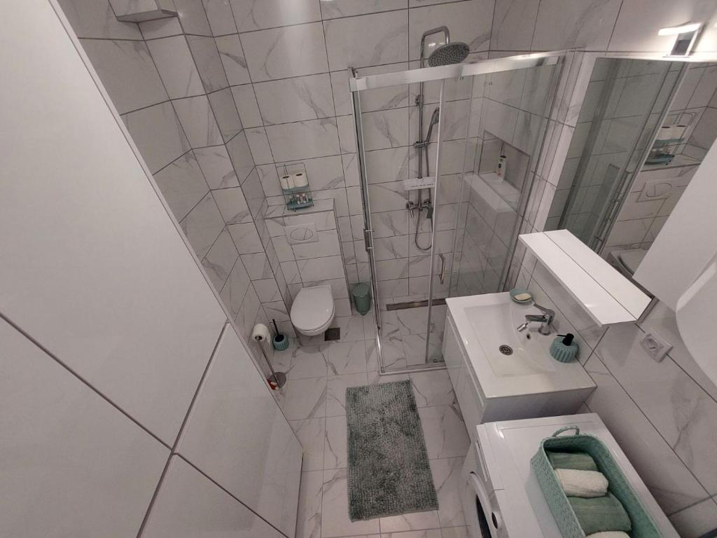 a white bathroom with a sink and a shower at Kalina Trebinje in Trebinje