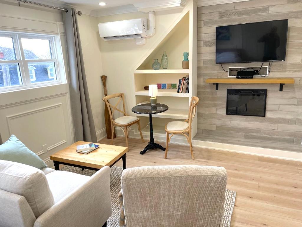 a living room with a couch and a tv on a wall at Water Street and HarborGate Condos & Studios in St. John's