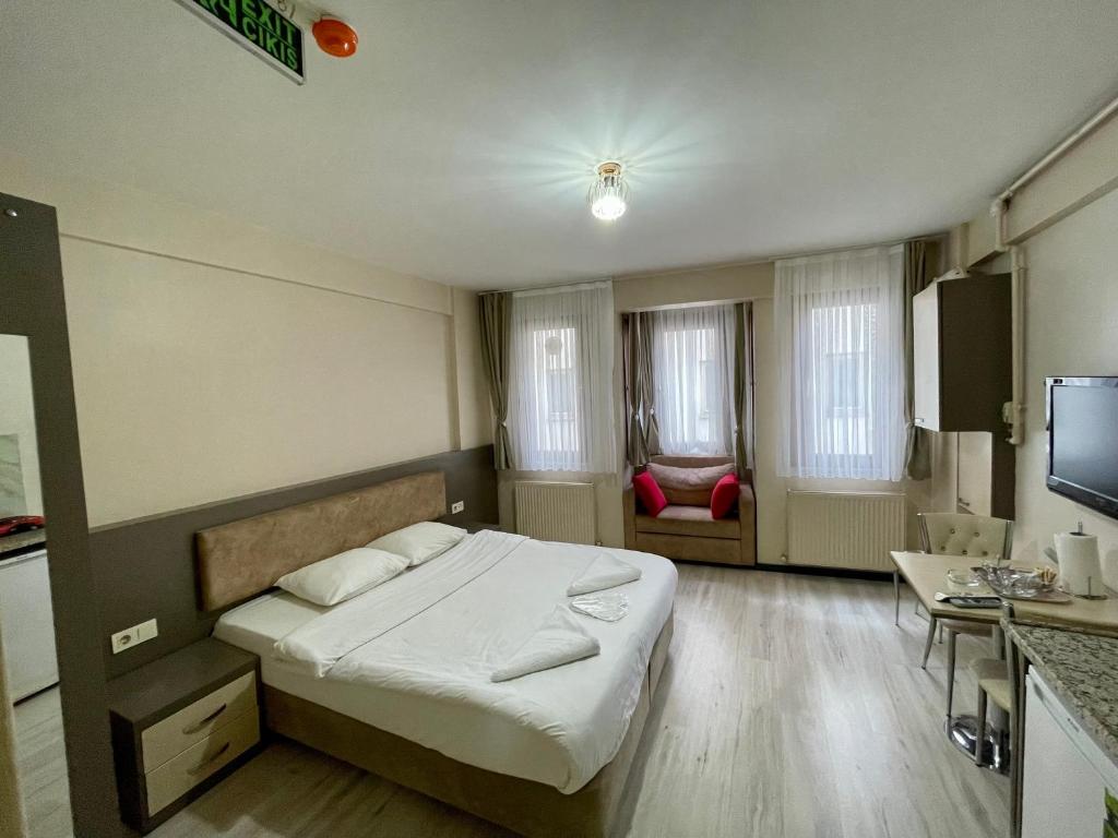 um pequeno quarto com uma cama e uma televisão em Dizayn Residence em Istambul