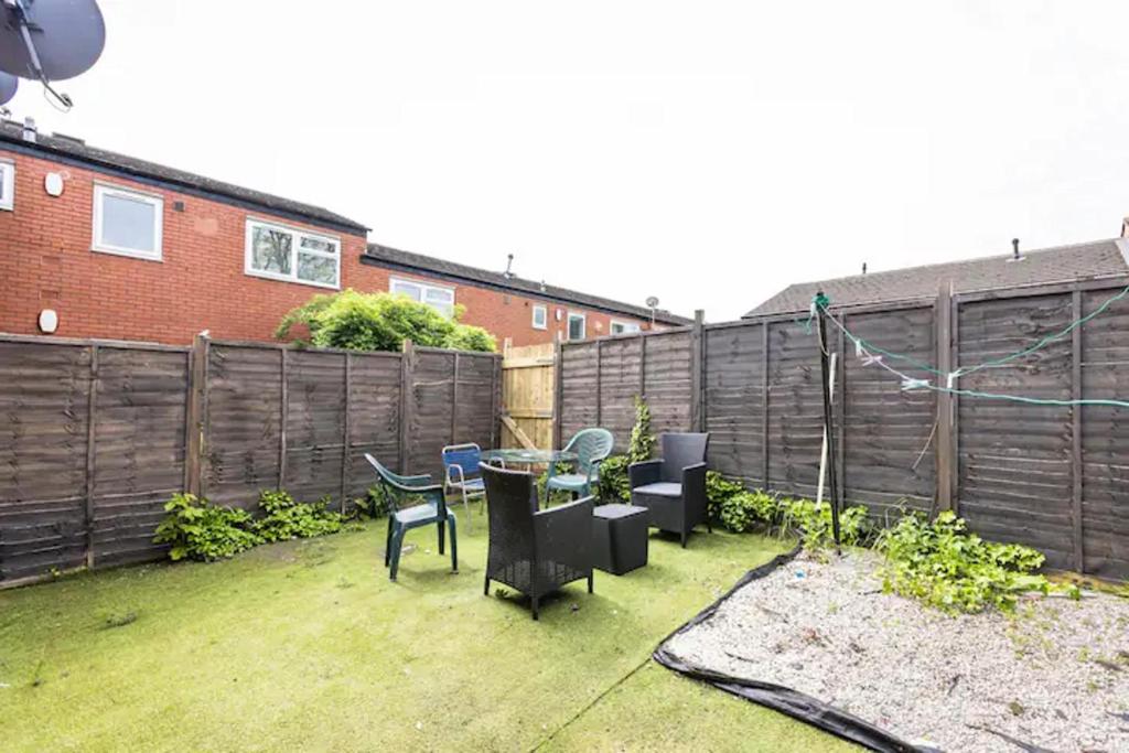 a backyard with a table and chairs and a fence at Mordenised 2 Bedroom House close to City Centre in Leeds
