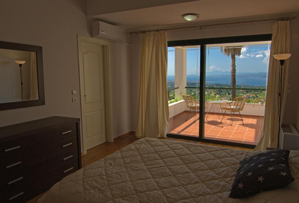 um quarto com uma cama e vista para um pátio em Amazing Villa with private pool em Markópoulon Oropoú