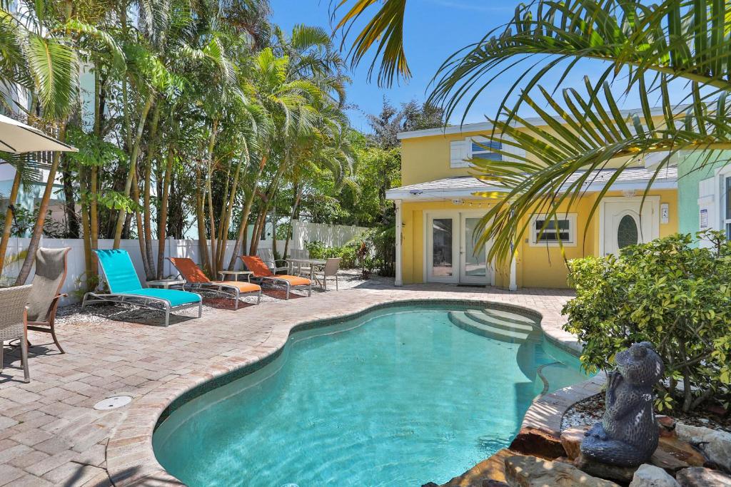 a swimming pool in front of a house with palm trees at Casa Del Sol A in Bradenton Beach