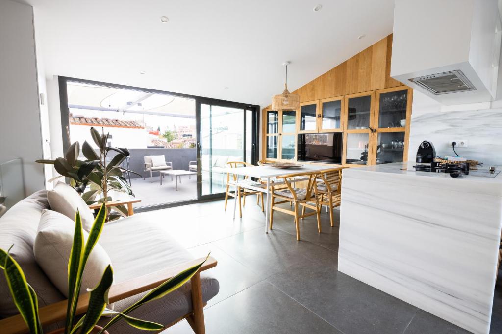 kuchnia i salon ze stołem i krzesłami w obiekcie Apartamento ático en el casco antiguo w mieście Mataró