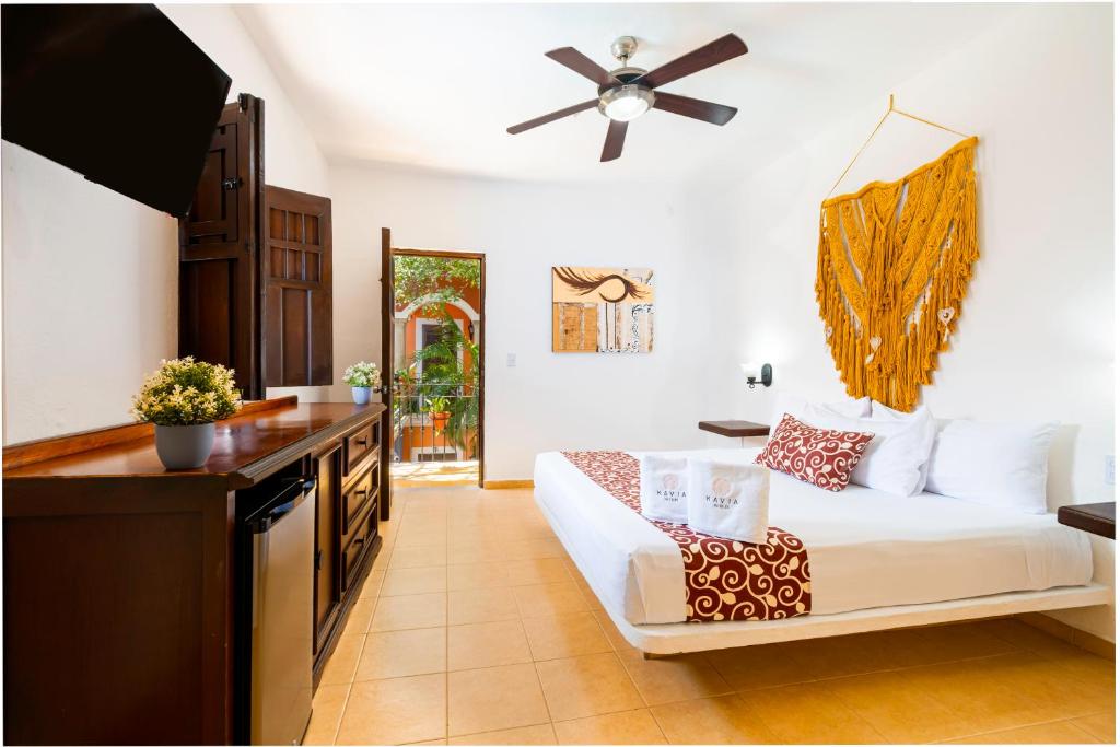 a living room with a white couch and a ceiling fan at Hotel Casa de las Flores in Playa del Carmen