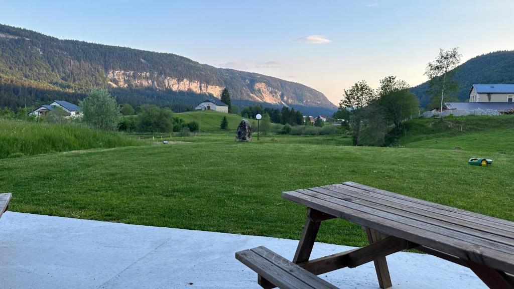 um banco de madeira sentado em cima de um campo em Les Chamois em Lajoux