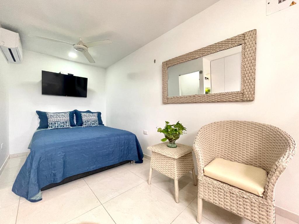 sypialnia z łóżkiem, krzesłem i lustrem w obiekcie Aparta estudios nuevos Mubarak w mieście Barranquilla