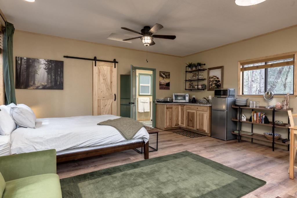 a bedroom with a bed and a kitchen at Little House in the Big Woods in Forest Ranch