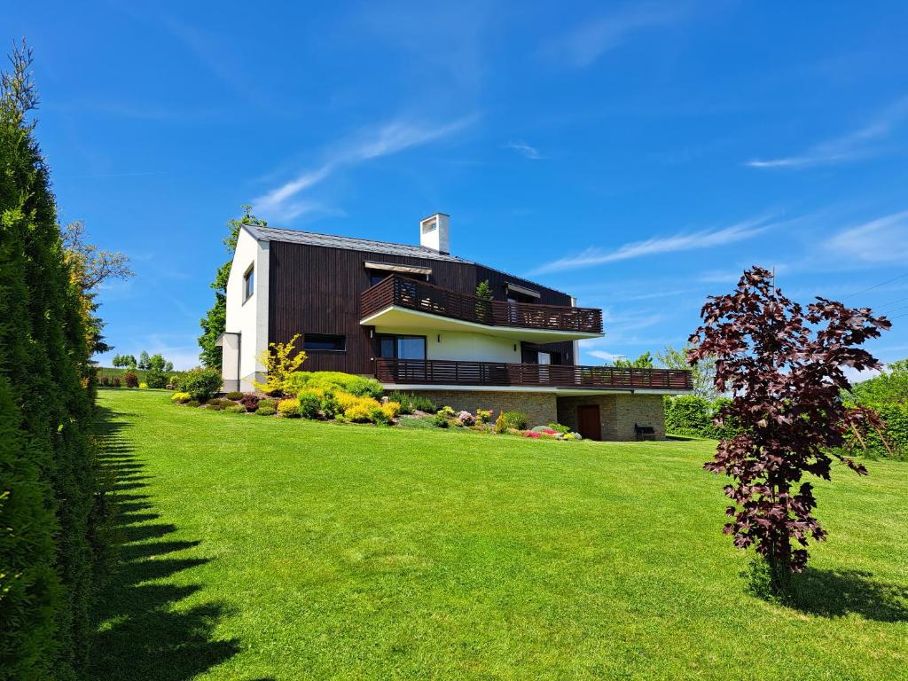 a house with a green lawn in front of it at Apartmány Hutisko 769 in Hutisko