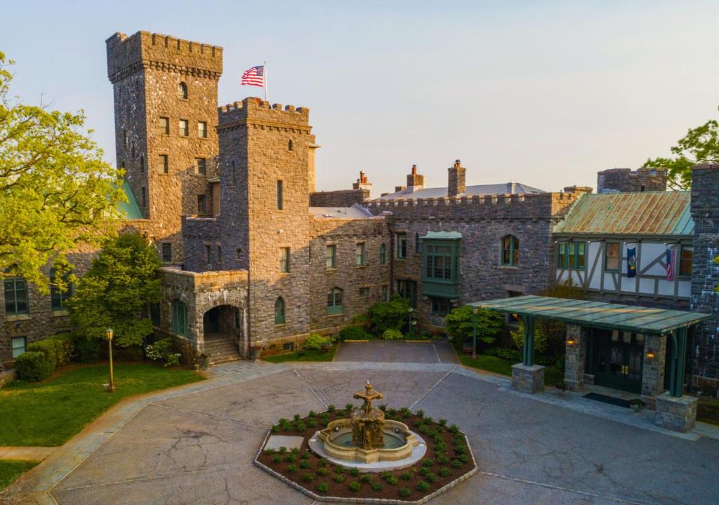 un grand château avec une fontaine devant lui dans l'établissement Castle Hotel & Spa, à Tarrytown